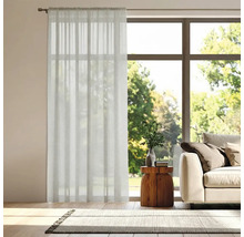 Woonkamer met gordijn voor het raam, bank en vloerkleed