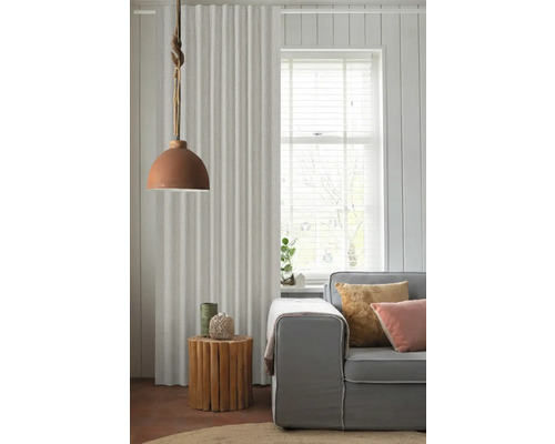 Woonkamerscène met gordijn, lamp, bijzettafel en bank voor een gezellige sfeer.