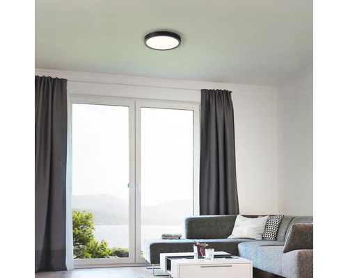 Woonkamer met plafondlamp en grote ramen