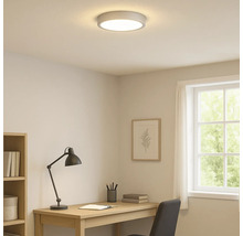 Verlichte studeerkamer met plafondlamp, bureau en raam.