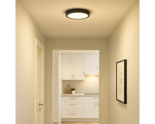 Hal met ronde plafondlamp en uitzicht op een keuken met witte meubels