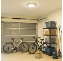 Een garage met fietsen, een rek en een plafondlamp.