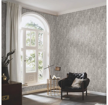 Woonkamer met patroonbehang, fauteuil en raam