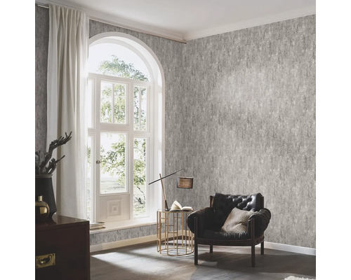 Woonkamer met patroonbehang, fauteuil en raam