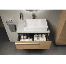 Badkamer met wastafel, open ladekast en handdoeken