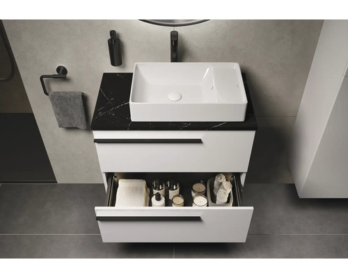 Moderne badkamer met wit wastafelmeubel, zwart marmeren blad en open lade-inhoud