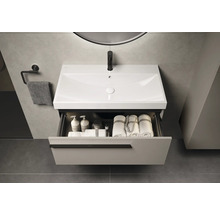 Wastafel met open lade, handdoeken en badkamerbenodigdheden in een moderne badkamer