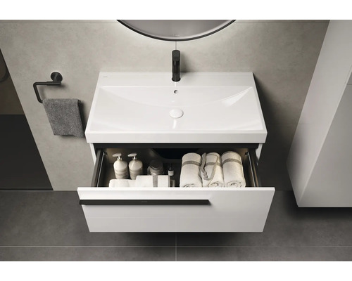 Wastafelonderkast met open lade, handdoeken en verzorgingsproducten in de badkamer