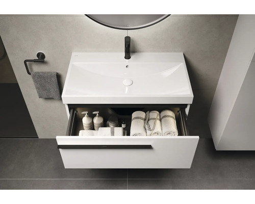 Moderne badkamer met witte wastafelonderkast, open lade en handdoeken