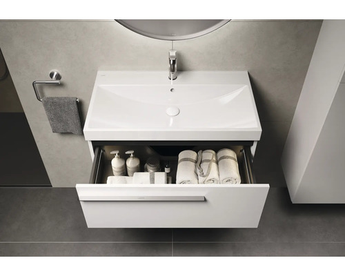 Badkamer wastafelonderkast met open lade, met handdoeken en badkamerbenodigdheden erin.