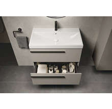 Wastafelonderkast met open lade, handdoek en badkamerartikelen in de badkamer.