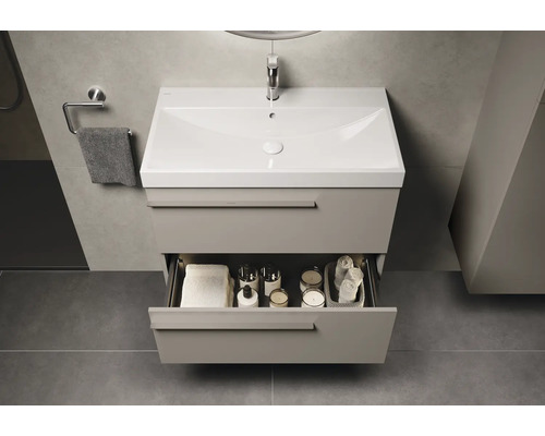 Wastafelmeubel met open lade en badkameraccessoires in een moderne badkamer