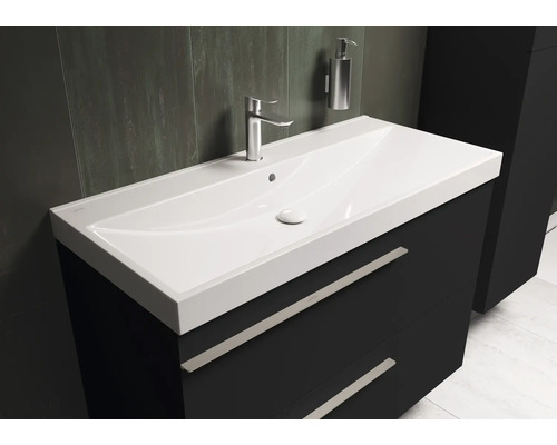 Wastafel met onderkast, kraan en zeepdispenser in de badkamer