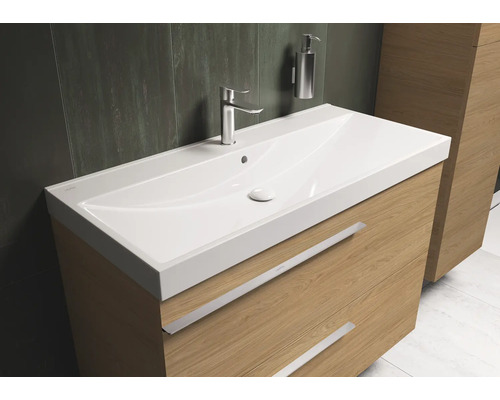 Wastafelcombinatie met wastafel, kraan en zeepdispenser in de badkamer.