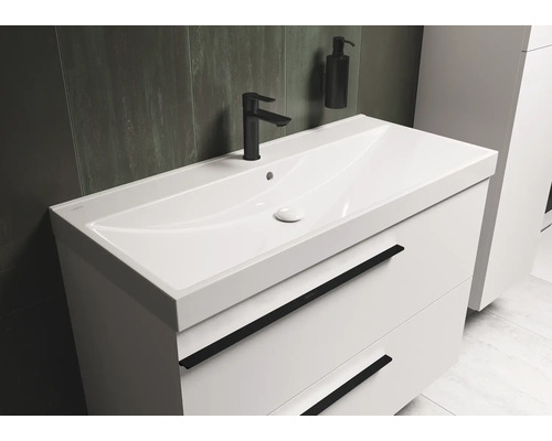 Witte wastafelonderkast met zwarte kraan en zeepdispenser in de badkamer