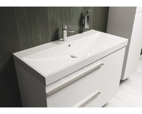 Witte wastafel met twee lades, kraan en zeepdispenser in de badkamer