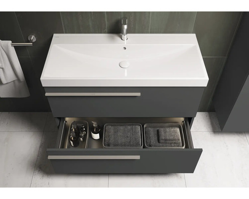 Wastafelonderkast met open lade, met cosmetica en handdoeken in de badkamer.