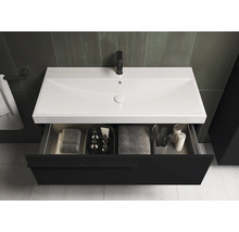 Wastafelonderkast met open lade, handdoeken en badkamerartikelen