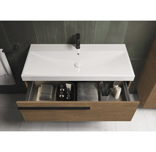 Wastafelonderkast met open lade, voorzien van handdoeken en badkamerbenodigdheden