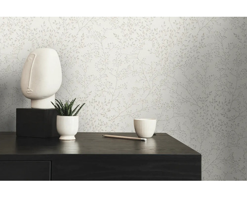 Scene met een behang met bloemmotief, een wit gezichtsbeeld, een vetplant in een pot en een potlood op een donkere tafel.