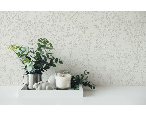 Stilleven met bloemetjesbehang, eucalyptus in een kan, kaars in glas en decoratief konijn op een dienblad