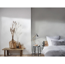 Lichte slaapkamer met decoratieve elementen en een bedlamp op een kruk