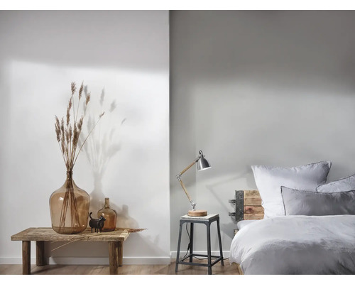 Lichte slaapkamer met decoratieve elementen en een bedlamp op een kruk