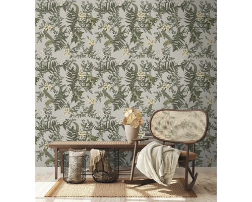 Decoratieve kamer met botanisch behang, bank en rotan schommelstoel.