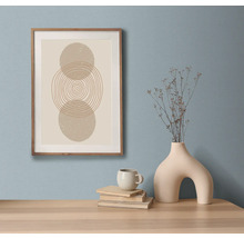 Decoratief stilleven met ingelijste kunstdruk, boeken, kop en vaas op een tafel