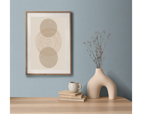 Decoratief stilleven met ingelijste kunstdruk, boeken, kop en vaas op een tafel