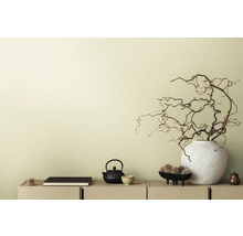 Decoratieve scène met theepot, boek en takken in vaas op een dressoir