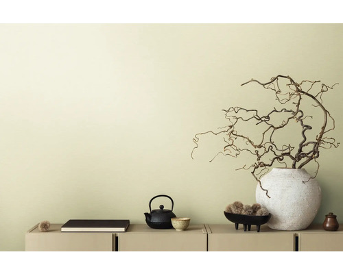 Decoratieve scène met theepot, boek en takken in vaas op een dressoir