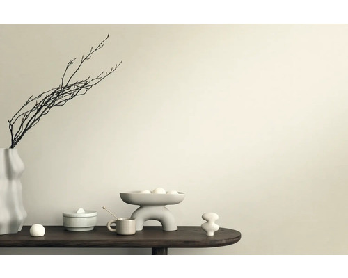 Decoratieve scène met vaas, takken, schaal en keramische figuren op een tafel