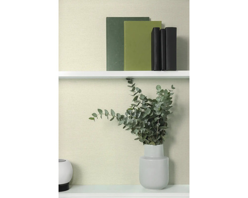 Decoratieve boeken en eucalyptus in vaas op een plank.