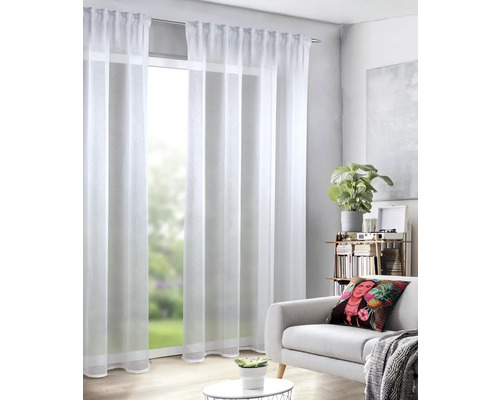 Woonkamer met witte, transparante gordijnen voor een raam