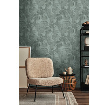 Inrichtingsvoorbeeld met een decoratief behang met plantenmotief, een fauteuil, een bijzettafel en een wandrek.