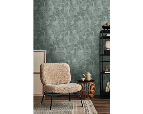 Inrichtingsvoorbeeld met een decoratief behang met plantenmotief, een fauteuil, een bijzettafel en een wandrek.