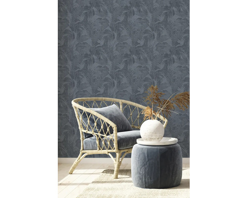 Scene met rotan stoel, kruk en behang met bloemmotief
