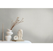 Decoratieve scène met kaarsen, vaas, takken, klok en sculptuur op een tafel.