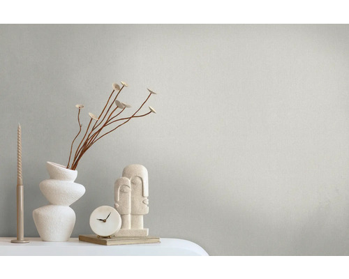 Decoratieve scène met kaarsen, vaas, takken, klok en sculptuur op een tafel.