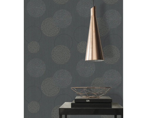 Close-up van een muur met een bloemmotief behang, een lamp en een tafel