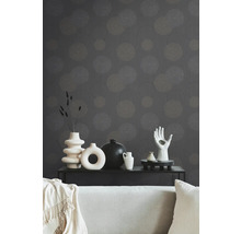 Decoratieve woonkamer met behang met motief, bank en diverse vazen op een zwarte tafel