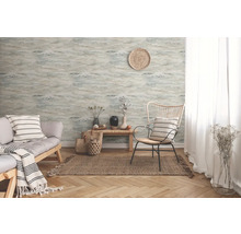 Woonkamer met patroonbehang, bank en fauteuil op een vloerkleed