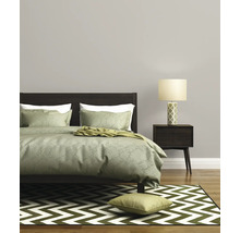 Slaapkamer met bed, nachtkastje, lamp en vloerkleed