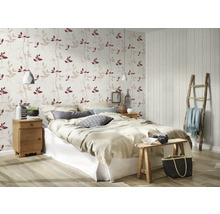 Slaapkamer met bed, nachtkastje en behang met bladerpatroon