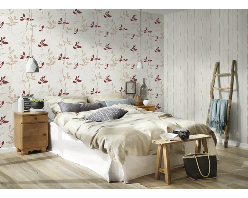 Slaapkamer met bed, nachtkastje en behang met bladerpatroon
