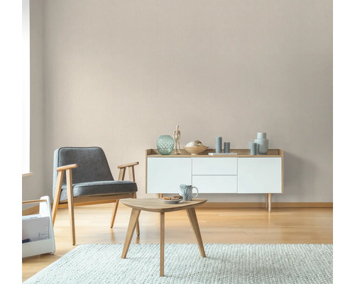 Woonkamer met fauteuil, tafel en dressoir in een licht design