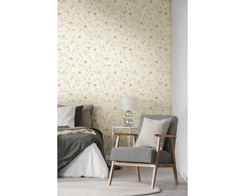 Slaapkamer met bloemetjesbehang, bed en fauteuil