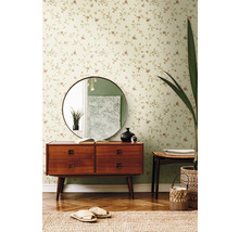 Woonkamer met bloemenbehang, ladekast, spiegel en decoraties.