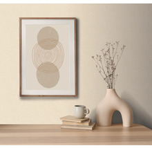 Decoratieve afbeelding met cirkelpatroon in houten lijst, op een tafel met decoratieve vaas en boeken